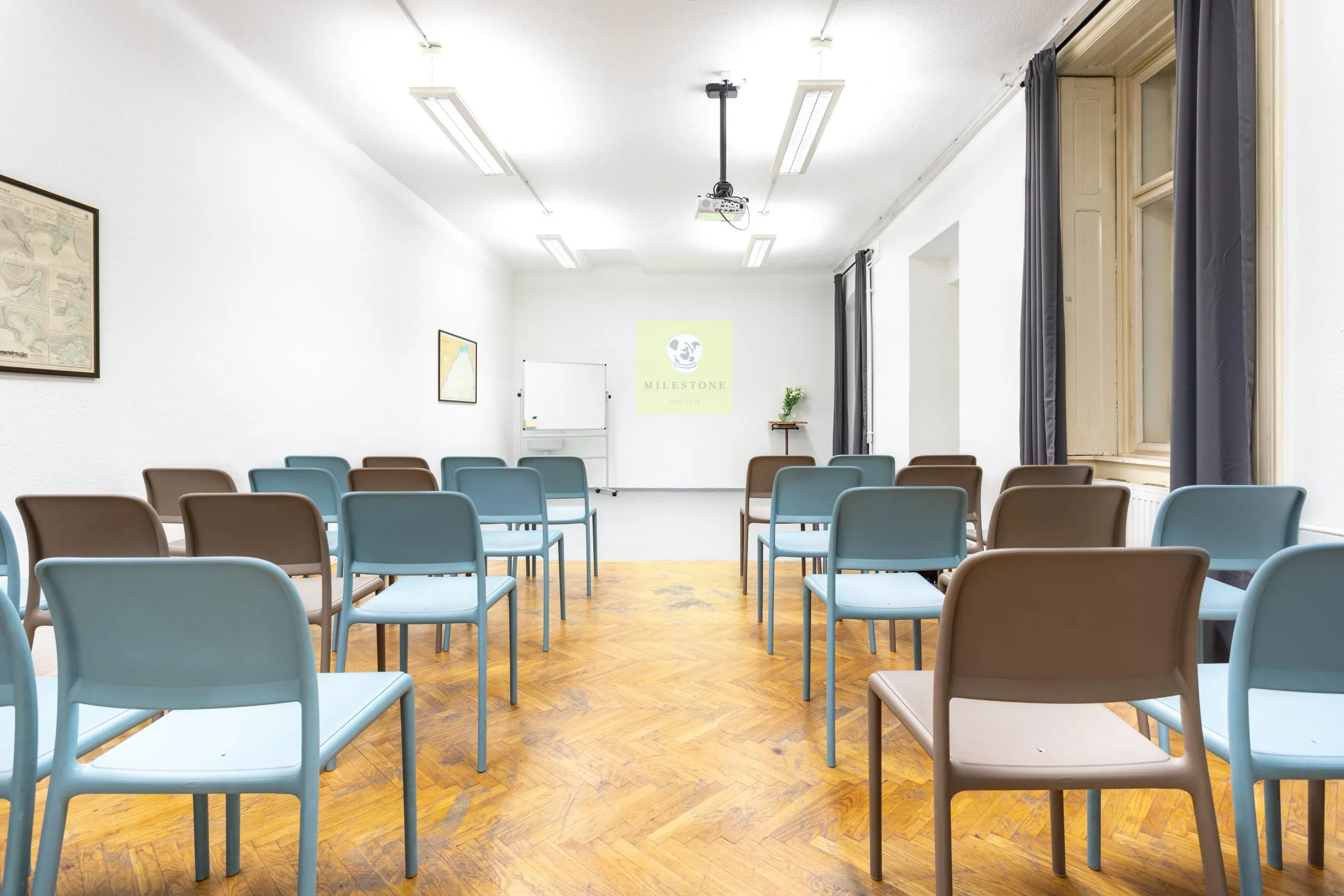 Grund terem színházi elrendezés – kék és barna széksorok, mennyezeti projektor
